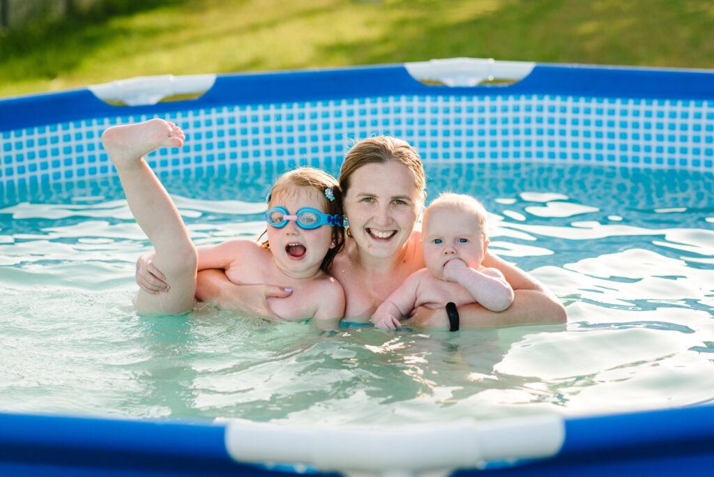 Familie spielt im Pool, Mutter und Kinder amüsieren sich im Metallrahmenpool, bzw. Stahlwandpool